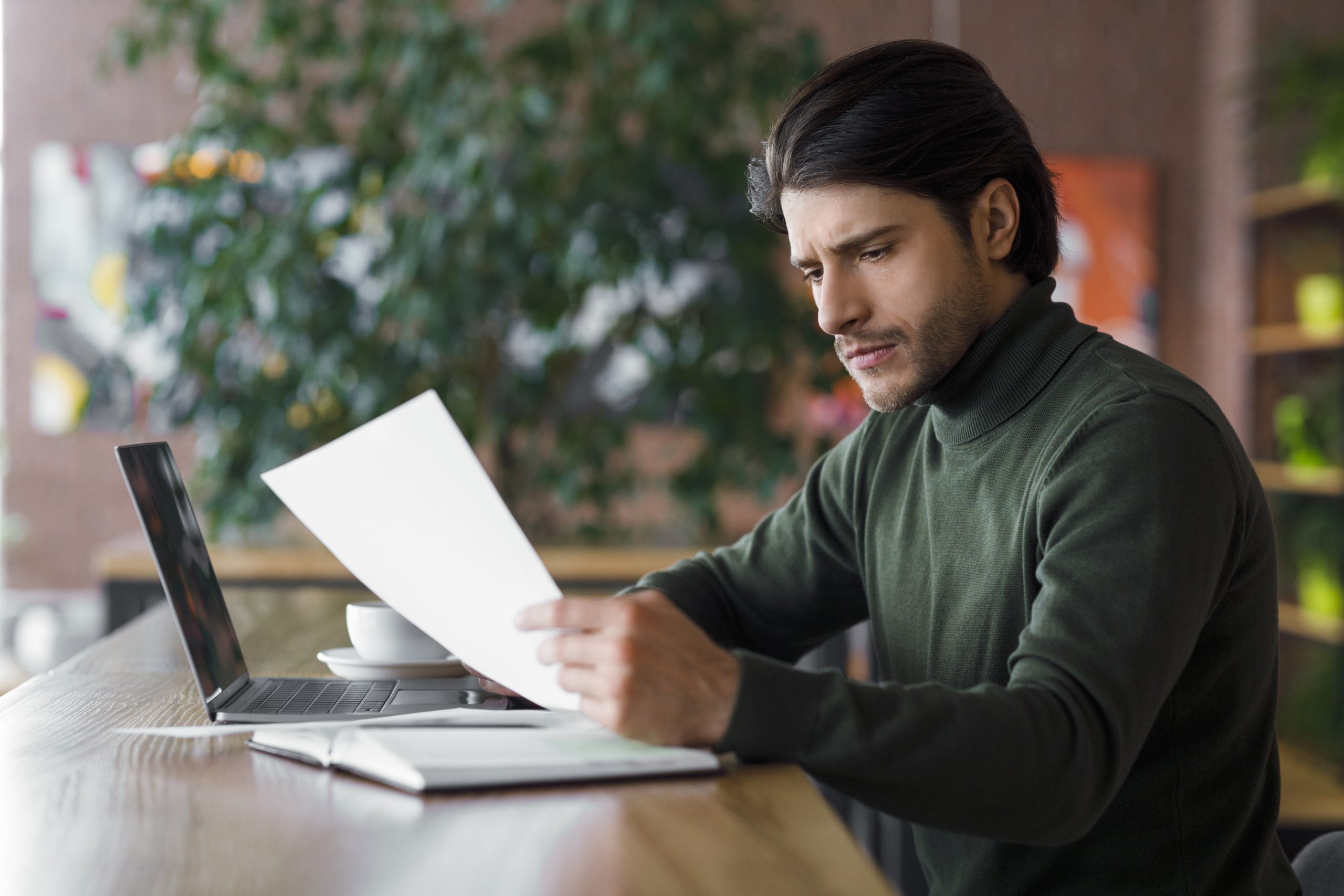 concentrated guy editor working with text at cafe